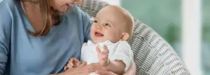 laughing baby in mom's arms