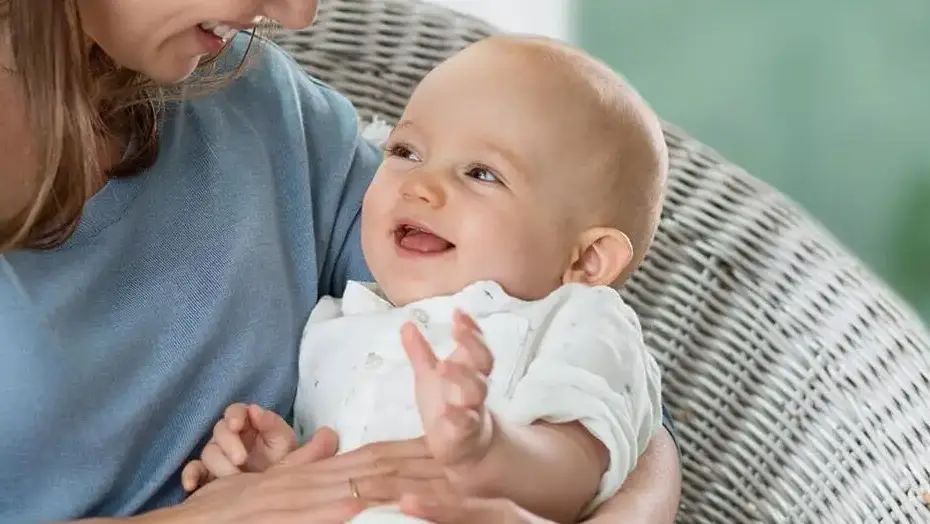 laughing baby in mom's arms